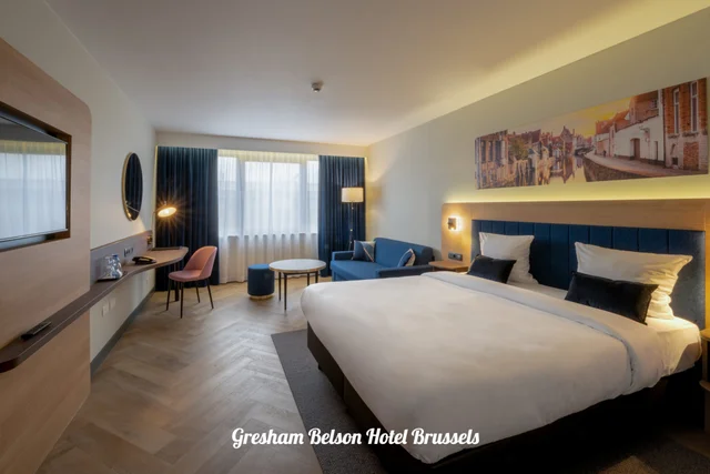 Chambre avec lit double, tête de lit bleue et coin salon
